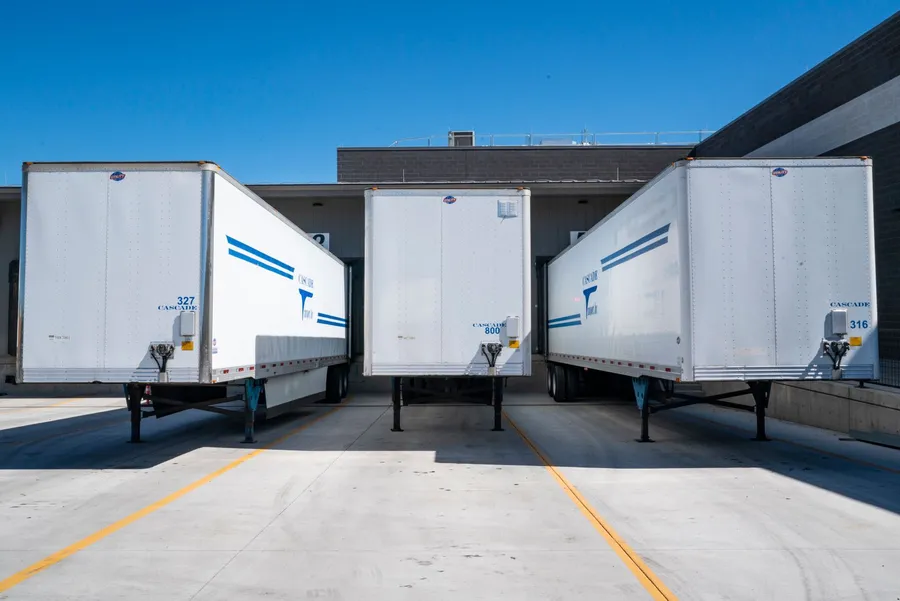 Camions de déménagement alignés au quai de chargement avant le départ