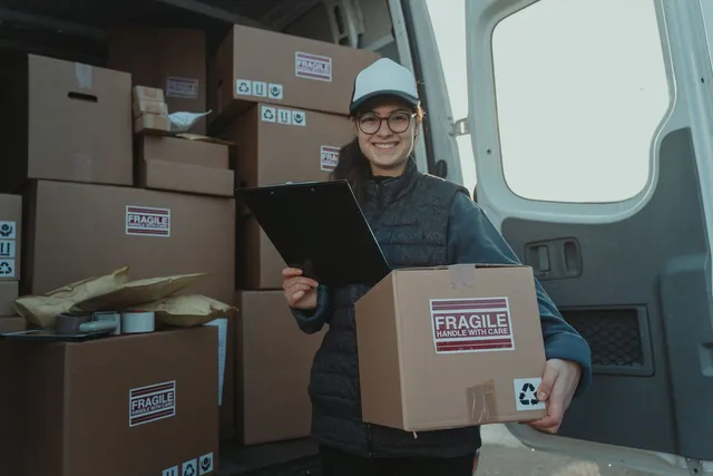 Déménageur vérifiant sa liste de tournée devant le camion de déménagement