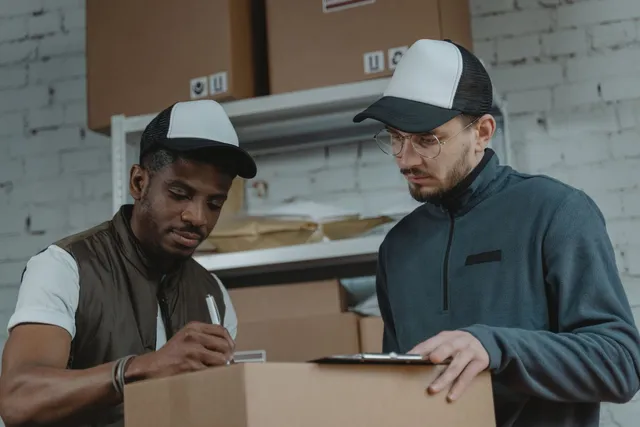 Déménageurs vérifiant l'inventaire des cartons avant le départ